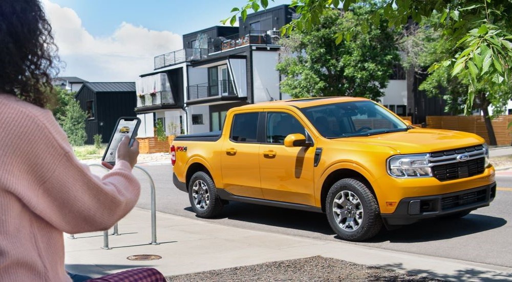 Yellow 2022 Ford Maverick parked by a curb after visiting a dealer with a used Ford for sale.