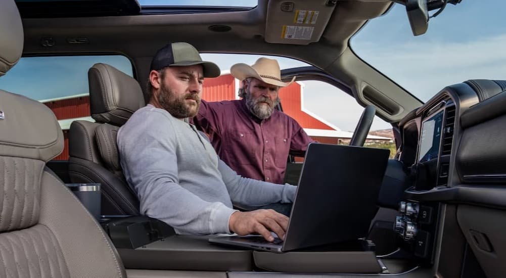 Two people working in a 2026 Ford F-150 for sale.