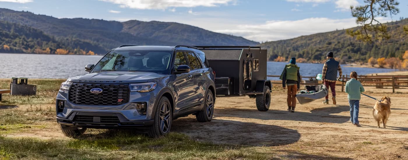 Grey 2026 Ford Explorer ST parked off-road near a lake.