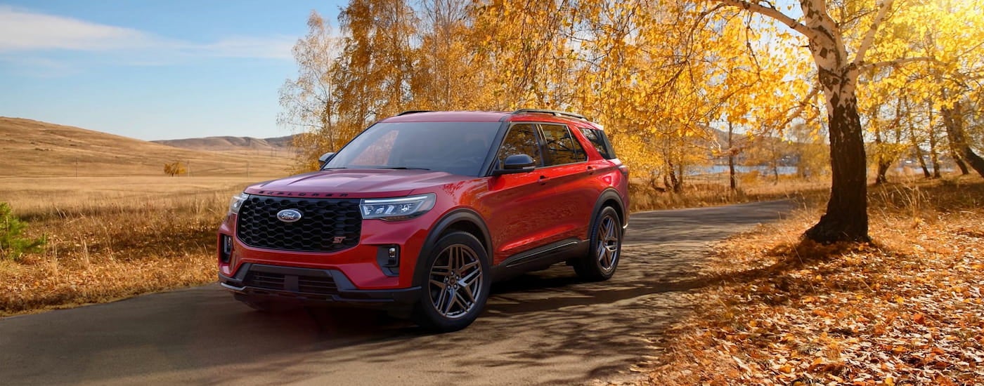 Red 2026 Ford Explorer ST driving down a road.