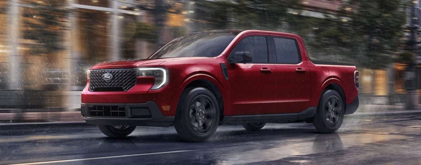 Red 2025 Ford Maverick driving down a city street.