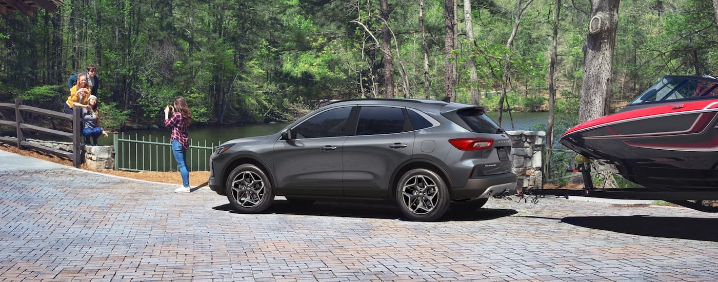 Rear of a grey 2026 Ford Escape towing a boat.