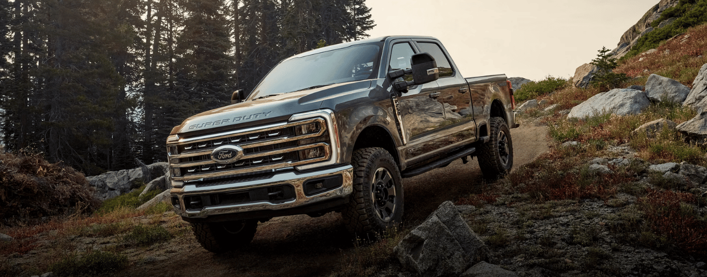 Blue 2026 Ford F-250 Super Duty driving down a hill while off-roading