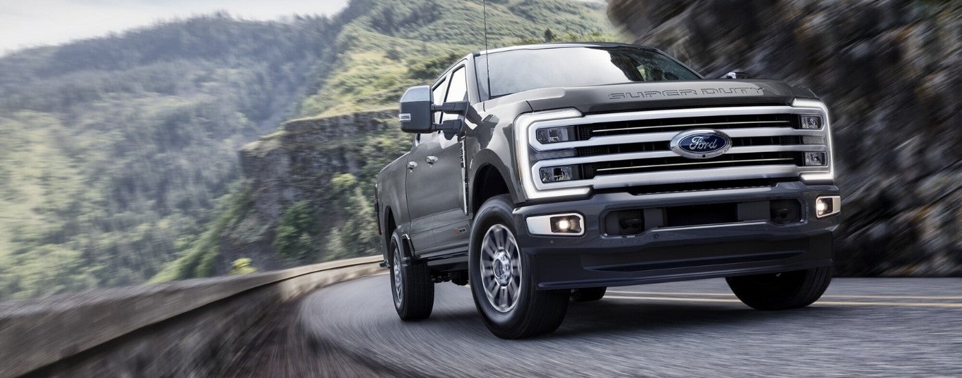 Black 2026 Ford F-350 driving around a bend.