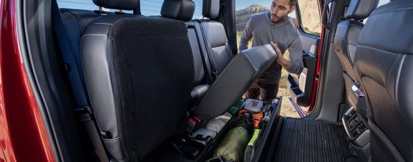Gear is show in the under seats storage in a red 2024 Ford F-150.