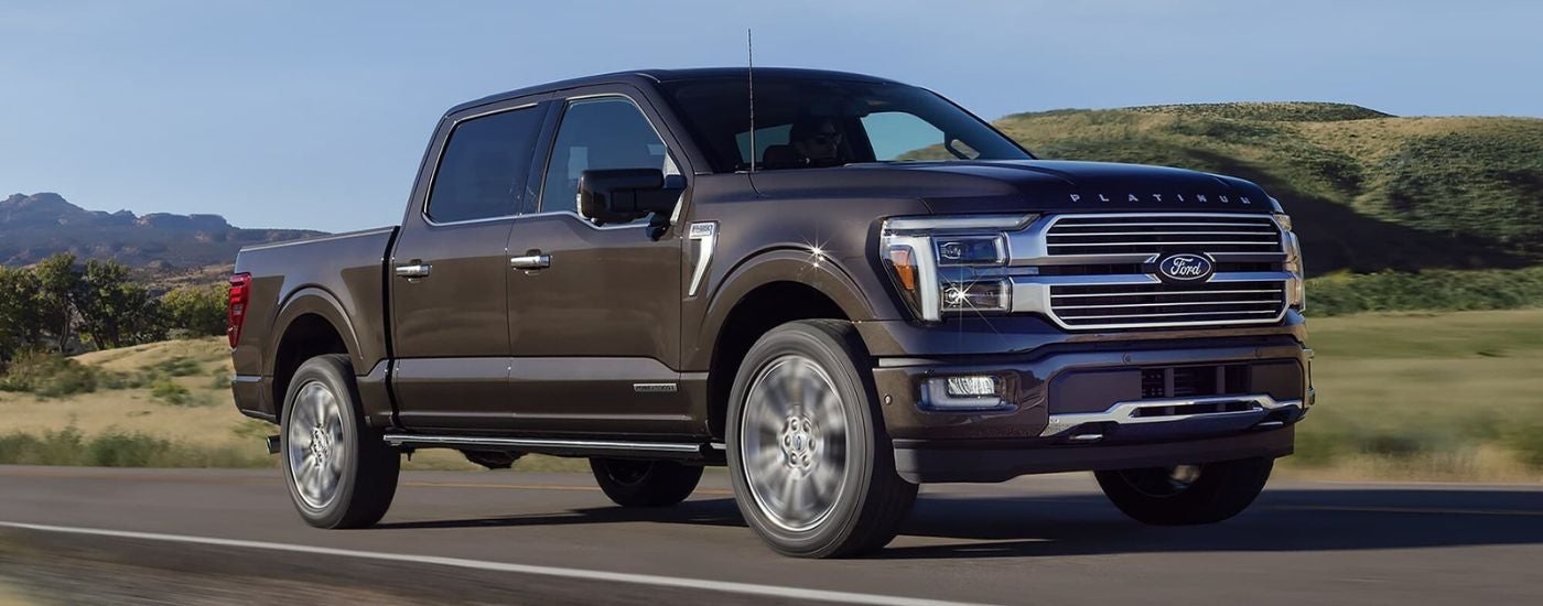 A brown 2024 Ford F-150 for sale near Portland is shown driving on an open road.
